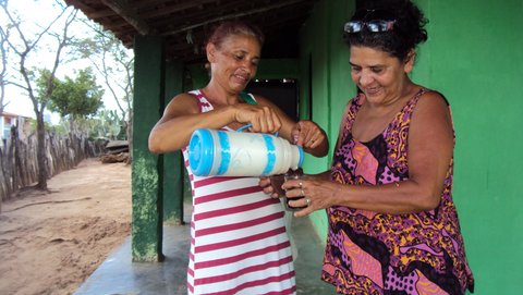 Dona Vanda serve café à jornalista Liliana Peixinho. Foto: Rudinho (Rudinei) e Andinho (Anderson).